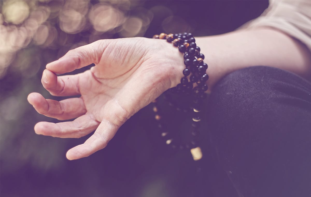 A person uses a Buddhist 'mudra' hand gesture while meditating